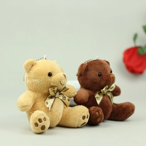 Detailed close-up of plush teddy bear charms with soft fur and printed ribbon bows