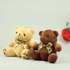 Detailed close-up of brown and cream plush teddy bear keychains with satin bow ties