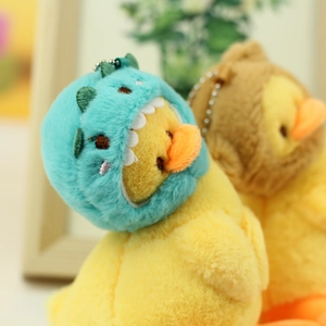 Close-up of cute plush ducklings in dinosaur and bear costumes with silver keychains