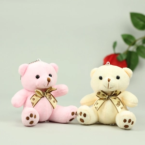 Detail of soft plush teddy bear pendants in pink and cream with brown satin bows