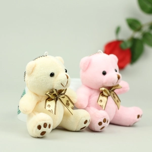 Detail of mini plush teddy bear charms in beige and pink with silk bow and bead chain