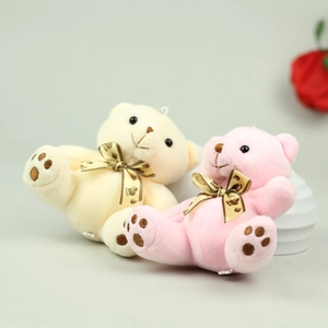 Detail of cream and pink plush teddy bears with satin bows and embroidered paw prints