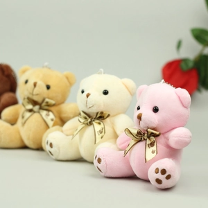 Detail of four colorful plush teddy bear charms with champagne bows for bags
