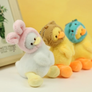 Close-up of cute plush ducks with bunny, bear, and dinosaur hats on metal chains