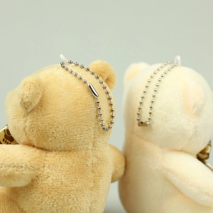 Detail of silver bead chain and soft plush texture on beige and khaki teddy bear charms