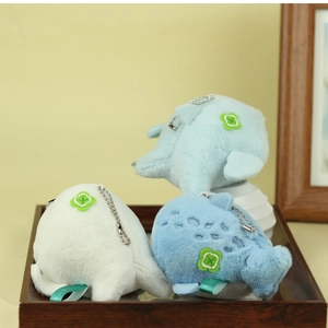 Close-up of cute plush whale and penguin charms on a wooden tray for bags