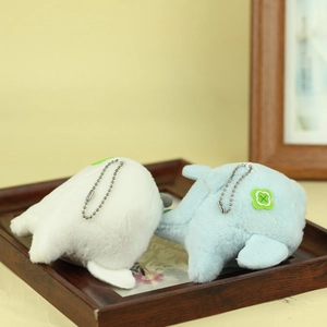 Close-up of small whale plush keychain charms with green clover embroidery and ball chains