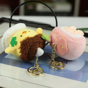 Close-up of strawberry plush charms with golden metal keychains and embroidery detail