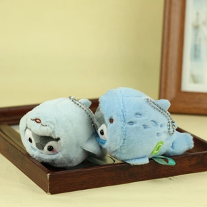 Close-up of cute plush penguin and whale charms with metal chains in a wood frame