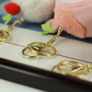 Macro shot of plush strawberry cream cheese charms with premium gold metal keyrings