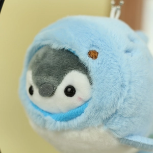 Detail of plush penguin keychain with blue sea animal hood and soft fuzzy texture
