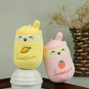 Dettaglio di ciondoli in peluche tè al latte gialli e rosa con ricamo Sweet Love