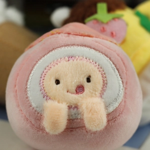 Close-up of pink plush charm with cute embroidery and soft texture on bag accessory