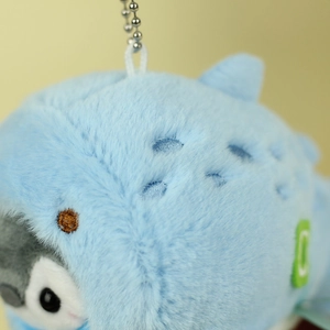 Close-up of cute penguin plush keychain with blue shark hoodie and silver bead chain