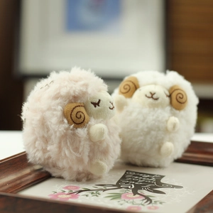 Close-up of soft plush lamb keychain with pink and white fur and spiral horns
