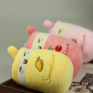 Dettaglio dei ciondoli in peluche a forma di tè al latte con ricami fini e consistenza morbida
