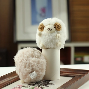 Close-up of cute plush sheep keychains in white and pink with soft curly faux fur