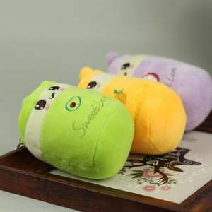 Dettaglio di tre ciondoli a forma di tazza di tè alla frutta in peluche multicolore