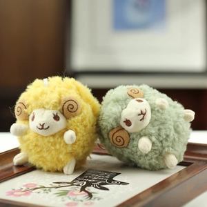 Close-up of fluffy yellow and green sheep plushies with embroidery and white hanging loops