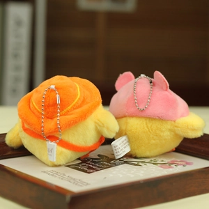 Detail of plush yellow chick keychains with cute hats in a wooden tray setting