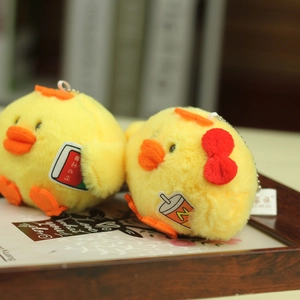 Close-up of cute plush yellow chick keychains with a red bow and book accessory