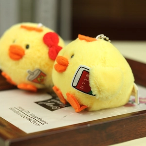 Detail of plush yellow chicken charms with a tiny book and drink cup accessories