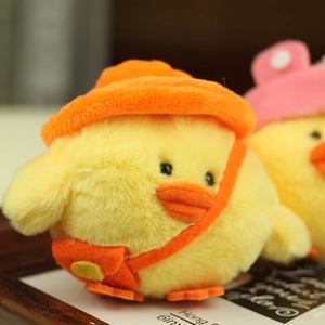 Close-up of cute plush yellow chicken with orange hat and mini crossbody bag detail
