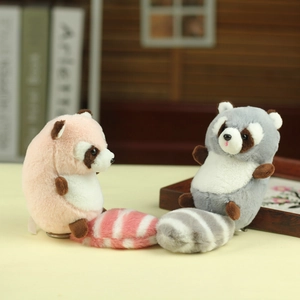 Detail of cute raccoon plush keychains in pink and grey with fluffy striped tails
