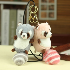 Detail of plush raccoon keychains in grey and pink with soft fur and metal clips