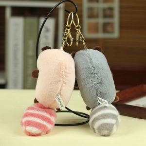 Detail of pink and grey plush cat keychains with striped tails and golden lobster clasps