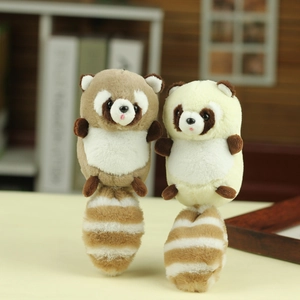 Detailed close-up of cute plush raccoon keychains in light brown and beige colors
