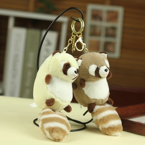 Detail of plush raccoon keychain with fluffy striped tail and golden metal ring