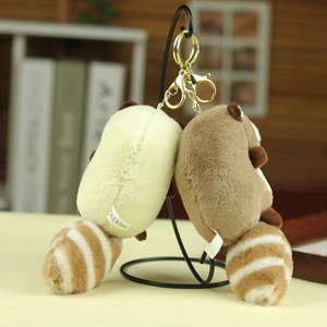Detail of cute raccoon plush keychains with striped tails and golden metal clasps