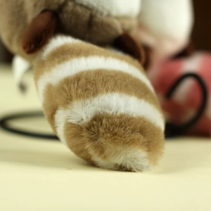 Close-up of the plush raccoon keychain's soft striped tail in brown and white tones