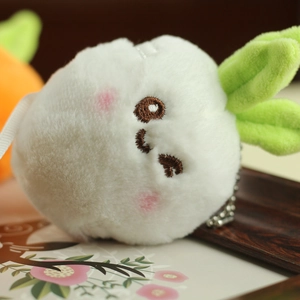 Close-up of cute plush white radish bunny pendant with embroidery and metal chain