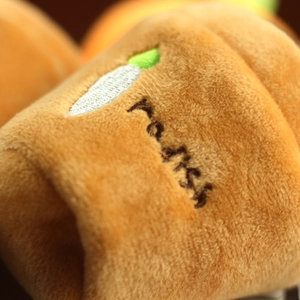 Close-up of plush material with carrot embroidery and radish text on the brown fabric