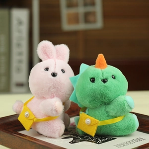 Close-up of cute plush bunny and dinosaur charms with mini yellow bags in a frame