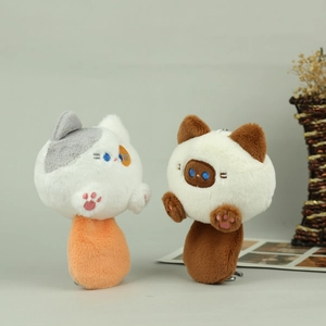 Detail of plush cat keychains featuring embroidered eyes and cute pink paw pads