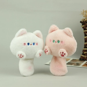 Detail of plush cat charms with soft white and pink fur and delicate paw embroidery
