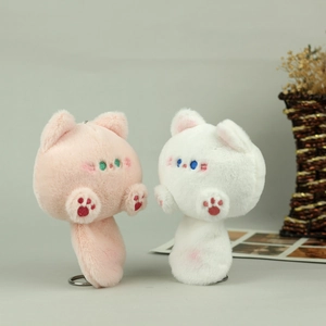 Close-up of pink and white plush cat charms with embroidered paw pads and metal keychain