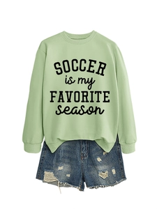 Detail des minzgrünen Fußball-Sweatshirts mit Rippbündchen und Distressed-Denim-Shorts