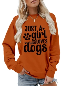 Close-up of orange crewneck sweatshirt with 'Just a girl who loves dogs' print and paw art