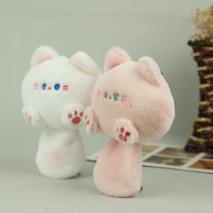 Detailed close-up of cute plush cat bag charms with soft faux fur and embroidered features