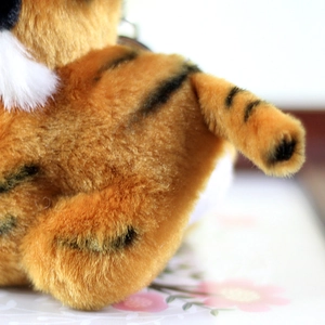Macro detail of the orange plush tiger toy showing soft faux fur and black stripe patterns