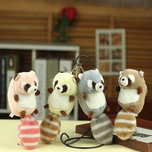 Plush raccoon keychain charms in four colors hanging on a decorative metal stand