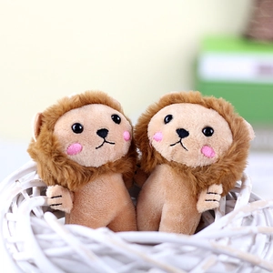 Close-up of two cute plush lion charms with blush cheeks in a woven basket