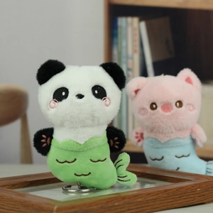 Detail von Plüsch-Meerjungfrau-Panda und Schwein-Schlüsselanhängern mit Stickerei