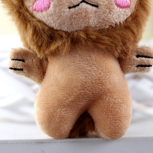 Macro detail of plush lion charm with soft fur texture and embroidered pink blush