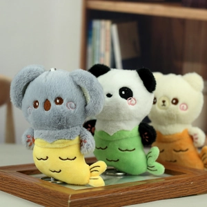 Drei Plüsch-Meerjungfrau-Anhänger mit Koala, Panda und Bär in einer Holzschale