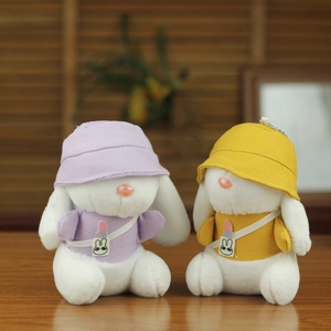 Dettaglio di portachiavi con coniglio di peluche e cappelli da pescatore viola e gialli